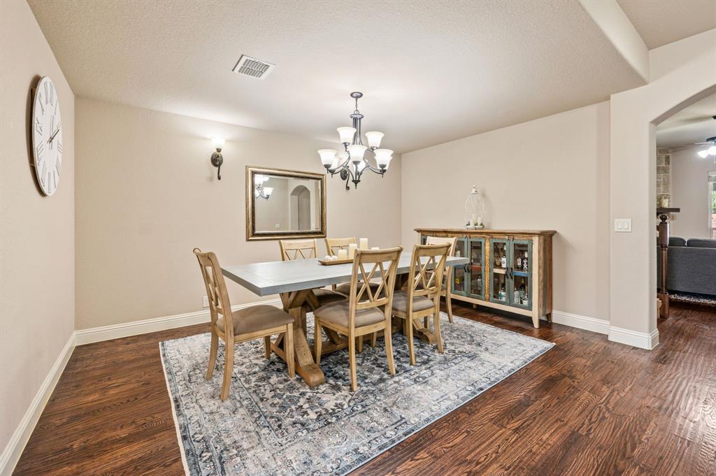 5209 Edgebrook Way Fort Worth, TX 76244 - Photo 9 of 33 a dining room with wooden floor a chandelier a wooden table and chairs