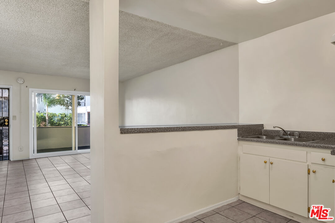 4956 Romaine Street Los Angeles, CA 90029 - Photo 14 of 25 a view of a kitchen with white cabinets and wooden floor