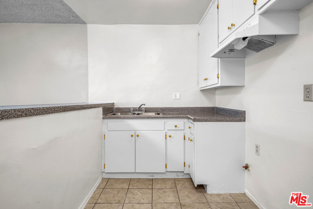 4956 Romaine Street Los Angeles, CA 90029 - Photo 17 of 25 a kitchen with white cabinets and sink