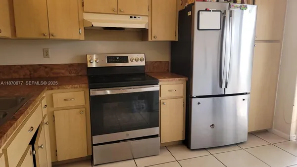 a kitchen with granite countertop a sink a stove and cabinets
