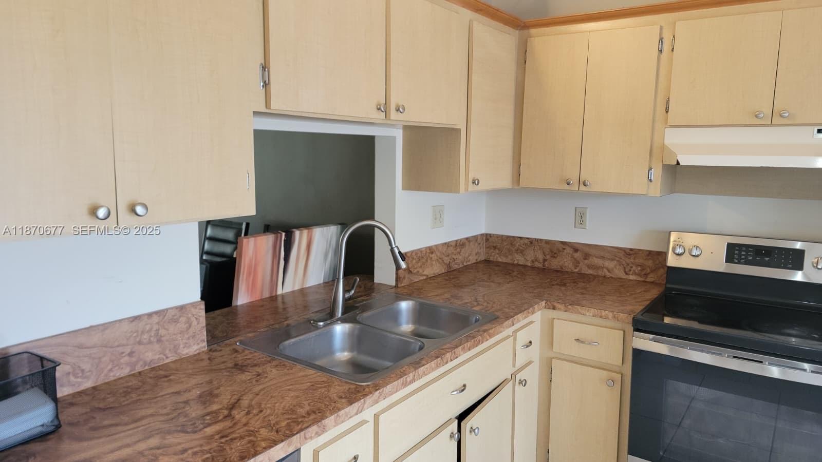 715 Banks Road Margate, FL 33063 - Photo 7 of 24 a kitchen with granite countertop a sink a stove and cabinets