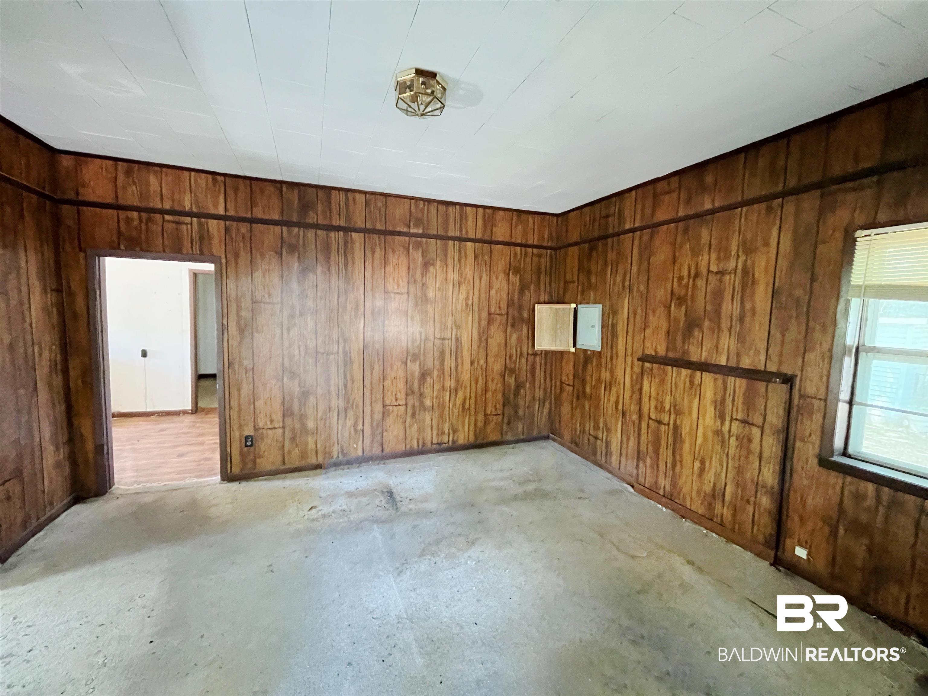 215 Adams Street Atmore, AL 36502 - Photo 3 of 7 Unfurnished room featuring wooden walls and concrete floors