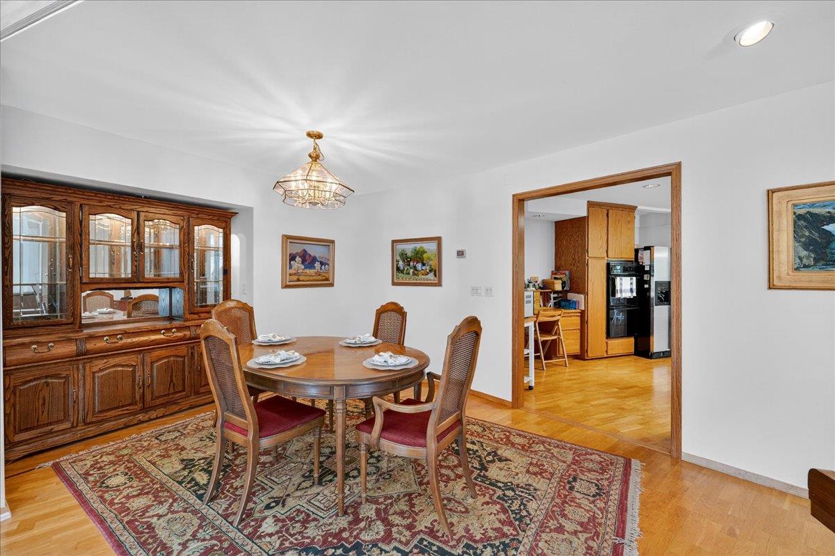 5224 Twin Falls Road Morgan Hill, CA 95037 - Photo 23 of 111 a dining room with wooden floor a chandelier a wooden table and chairs