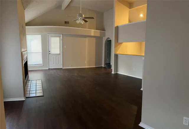 a view of a livingroom with wooden floor and a bathroom