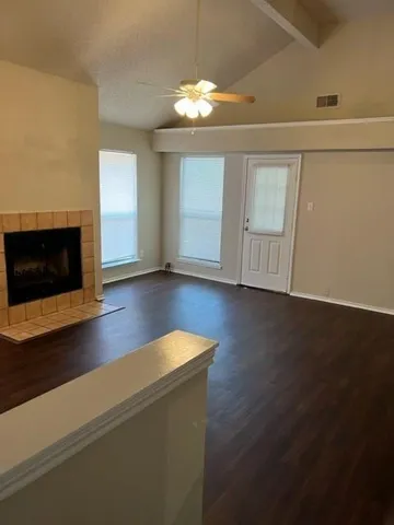 a view of a livingroom with wooden floor a fireplace and window
