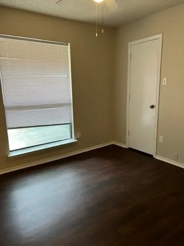 a view of a room has wooden floor and a window