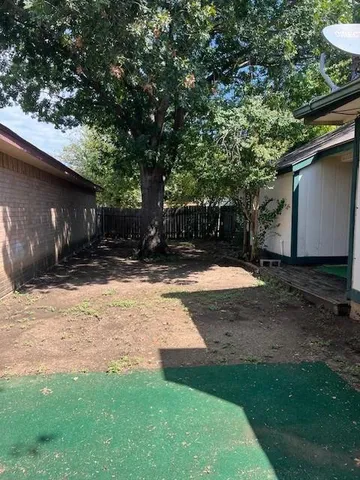 a view of a backyard with a tree