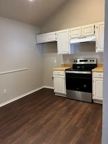 a kitchen with wooden floors and a stove top oven