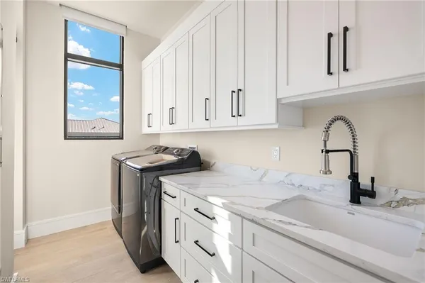 a kitchen with stainless steel appliances granite countertop a sink dishwasher a stove and a microwave oven with white cabinets