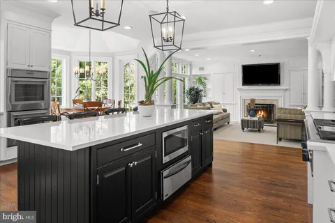 a kitchen with stainless steel appliances a sink a microwave a stove and white cabinets