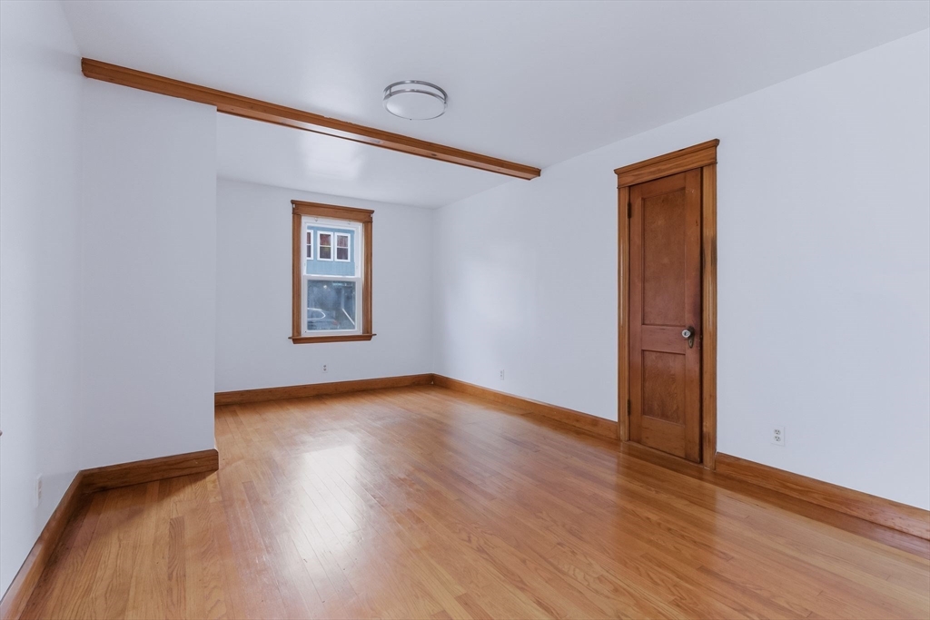 7 3rd Avenue Dudley, MA 01571 - Photo 12 of 42 a view of an empty room with wooden floor and a window