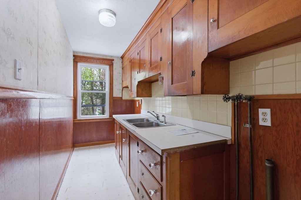 7 3rd Avenue Dudley, MA 01571 - Photo 4 of 42 a kitchen that has a sink a window and stainless steel appliances