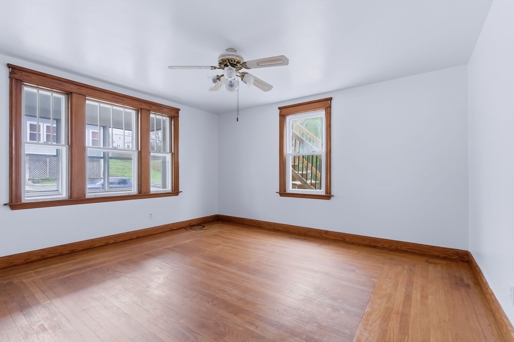 7 3rd Avenue Dudley, MA 01571 - Photo 6 of 42 a view of an empty room with chandelier fan and wooden floor