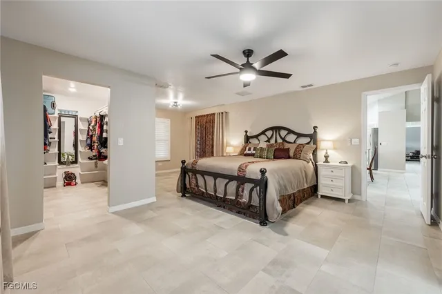 a bedroom with a large bed and a chandelier