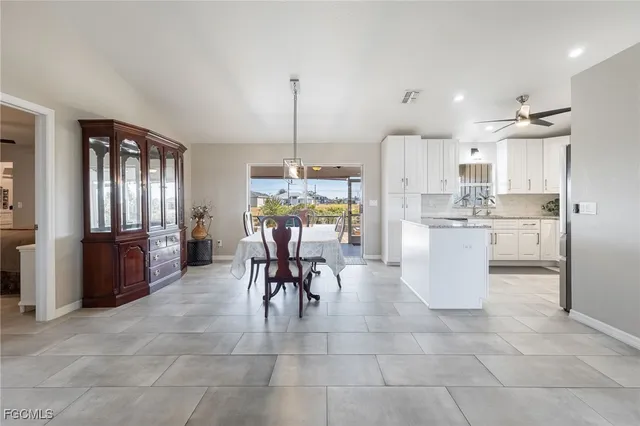 a kitchen with stainless steel appliances kitchen island granite countertop a refrigerator a stove a kitchen island a dining table and chairs