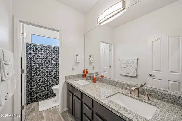 a bathroom with a granite countertop sink a mirror a and a shower