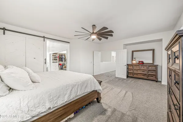 a bedroom with a large bed and a ceiling fan