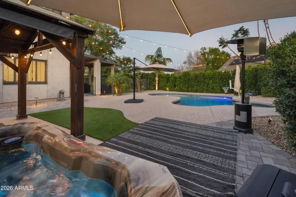 a view of a backyard with couches under an umbrella