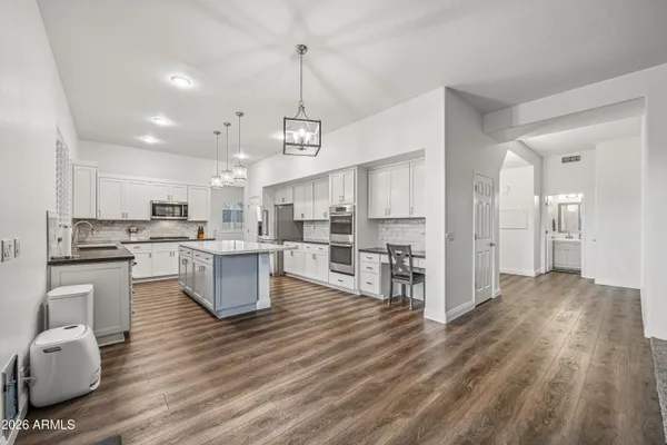 a kitchen with stainless steel appliances kitchen island hardwood floor sink and stove