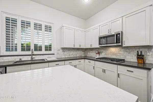 a kitchen with stainless steel appliances granite countertop a sink a stove top oven a counter space and cabinets