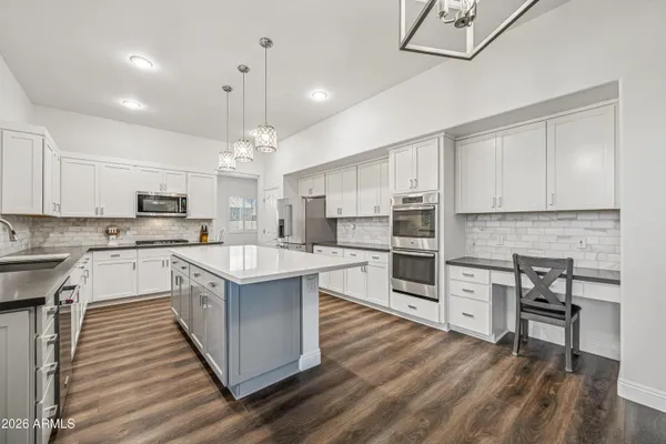 a kitchen with kitchen island granite countertop a sink cabinets and stainless steel appliances