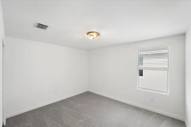 a view of a house with backyard and a large tree