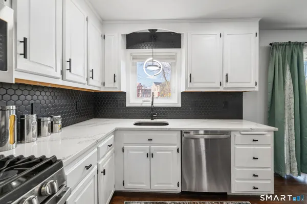 a kitchen with stainless steel appliances a stove a sink and a refrigerator