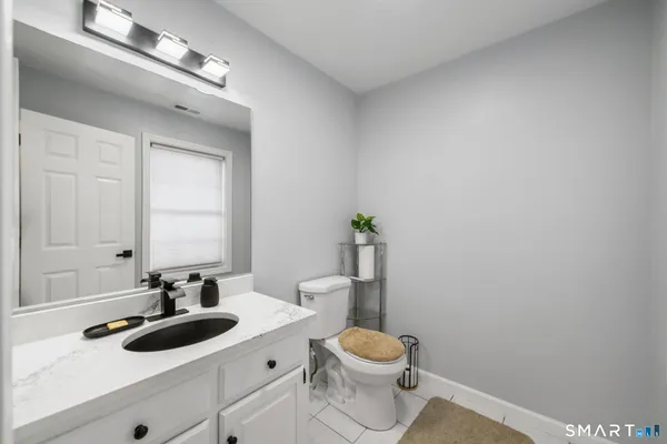 a bathroom with a toilet a sink and mirror