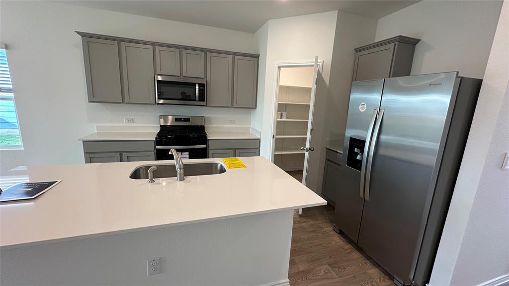 204 Inks Lane Kyle, TX 78640 - Photo 4 of 25 A well-appointed kitchen features stainless steel appliances and a generous pantry for optimal organization.