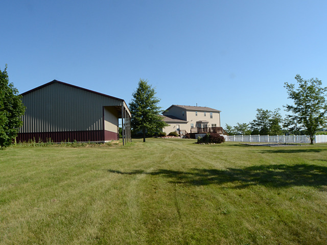 16732 Trask Bridge Road Pecatonica, IL 61063 - Photo 17 of 17 a view of a big house with a big yard potted plants and large tree