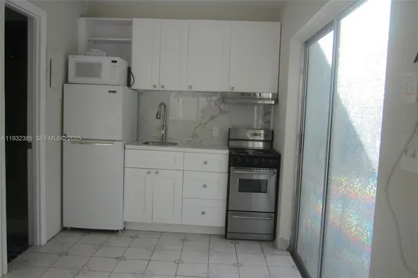 a kitchen with cabinets and a refrigerator