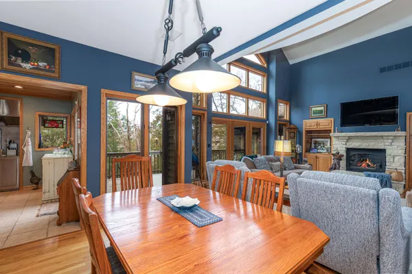 a kitchen with stainless steel appliances a stove a refrigerator a sink dishwasher and a dining table with wooden floor