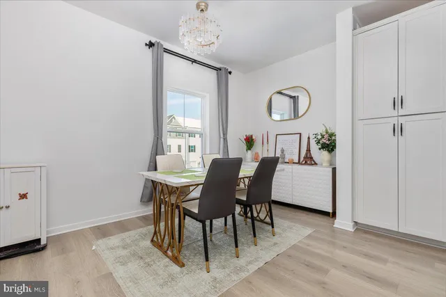 a dining room with furniture a chandelier and wooden floor