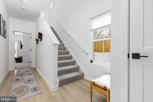 a view of a livingroom with wooden floor and stairs