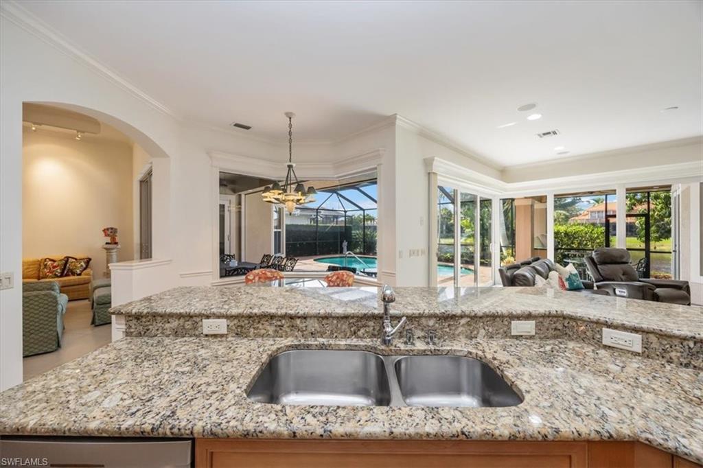 4971 Rustic Oaks Circle Naples, FL 34105 - Photo 15 of 50 a kitchen with a granite counter tops and a view of living room