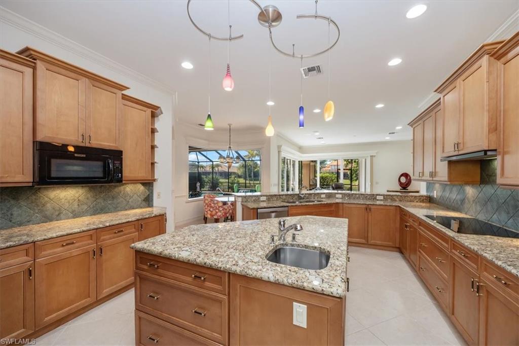 4971 Rustic Oaks Circle Naples, FL 34105 - Photo 16 of 50 a kitchen with stainless steel appliances granite countertop a sink and cabinets
