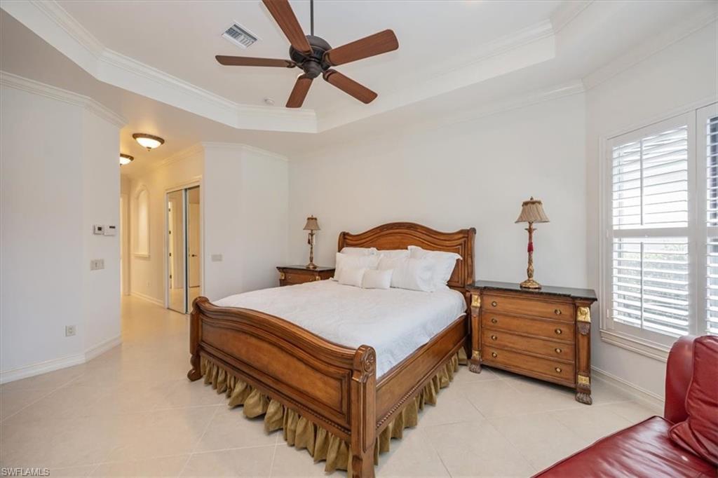 4971 Rustic Oaks Circle Naples, FL 34105 - Photo 21 of 50 a bedroom with a bed and a chandelier