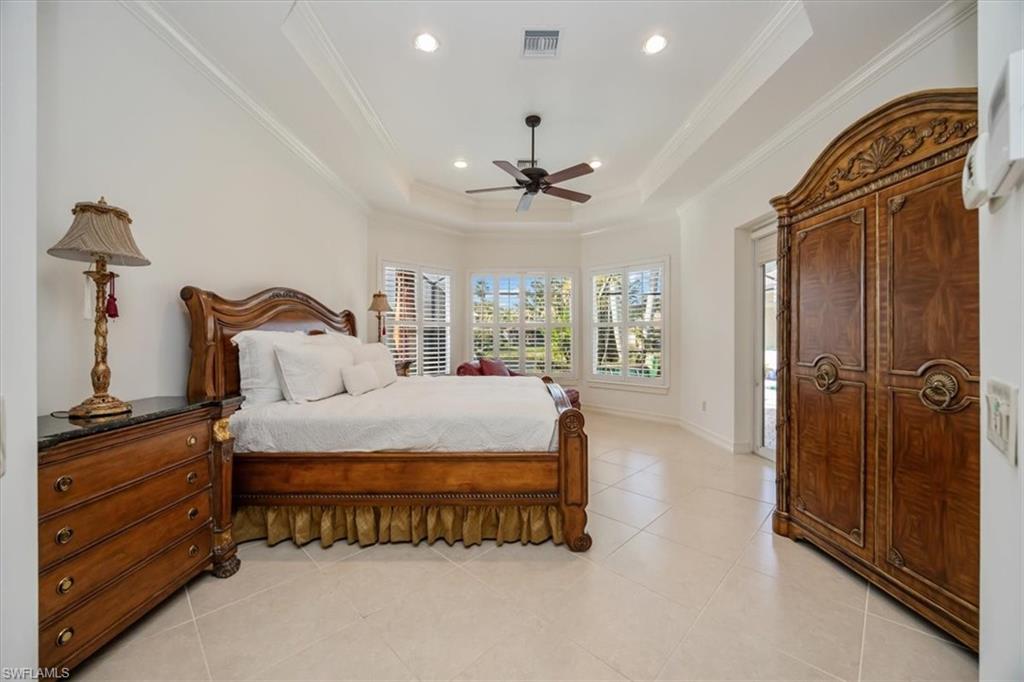 4971 Rustic Oaks Circle Naples, FL 34105 - Photo 22 of 50 a spacious bedroom with a bed and a chandelier