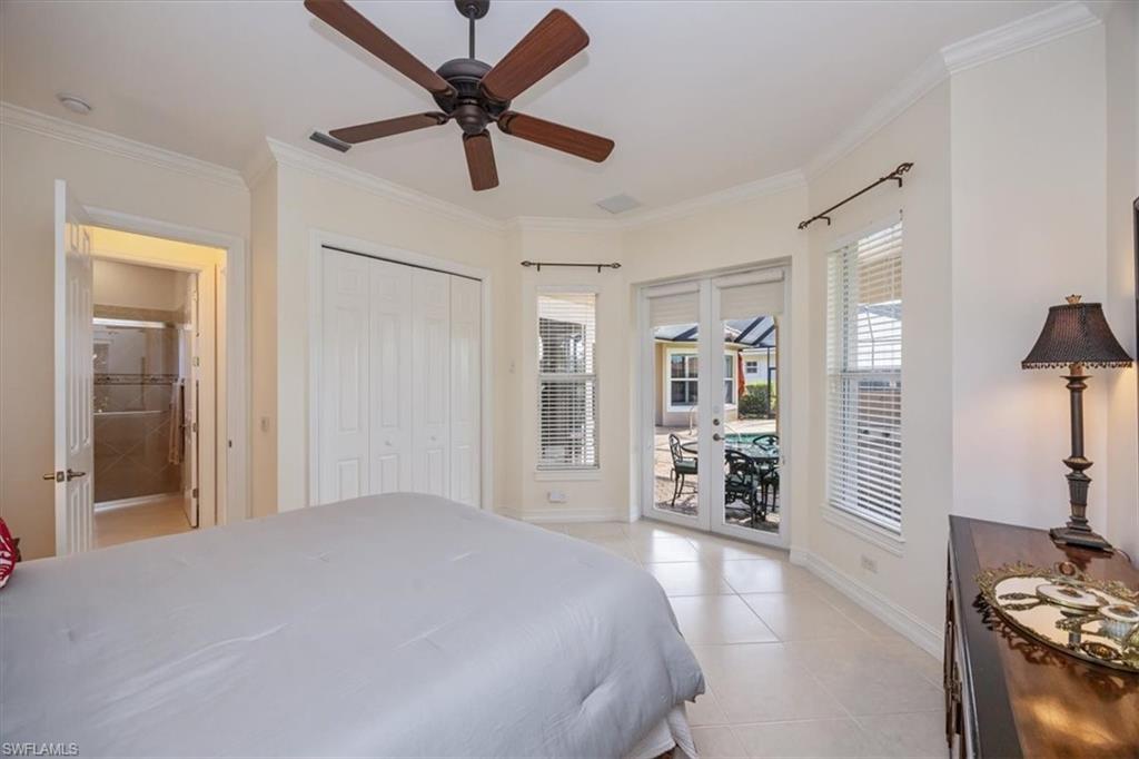 4971 Rustic Oaks Circle Naples, FL 34105 - Photo 25 of 50 a bedroom with a large bed and a chandelier