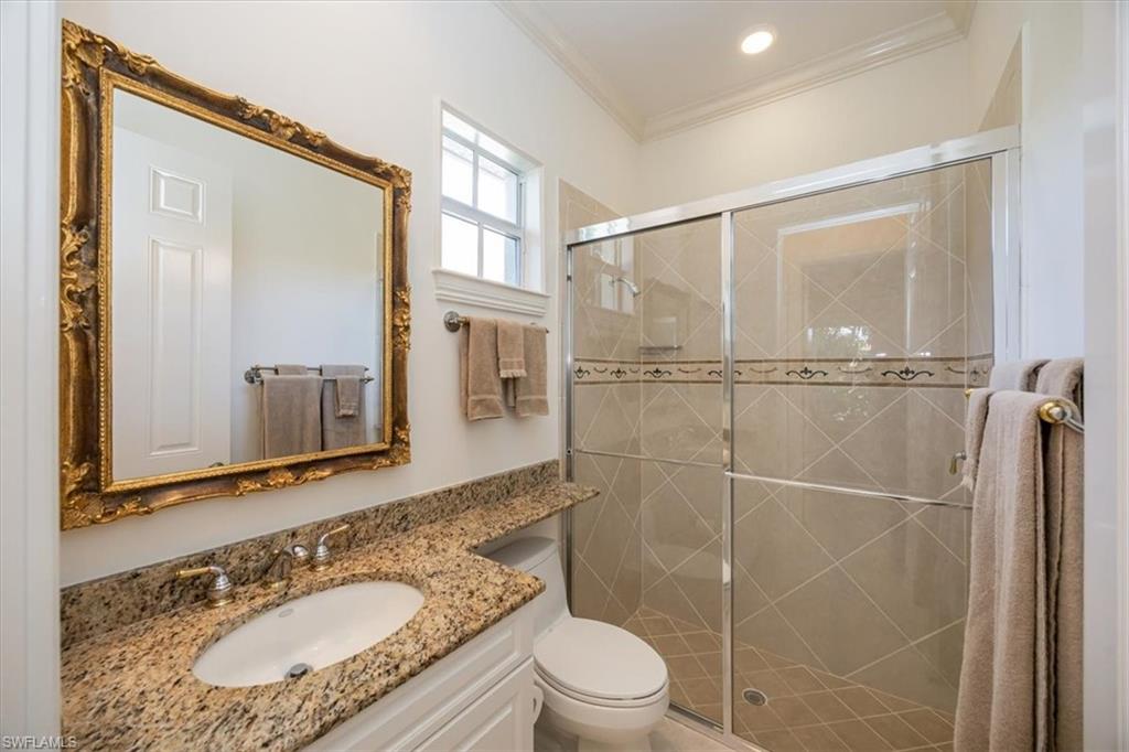 4971 Rustic Oaks Circle Naples, FL 34105 - Photo 28 of 50 a bathroom with a granite countertop sink toilet a mirror and shower