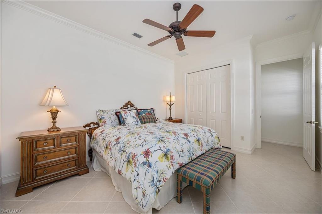 4971 Rustic Oaks Circle Naples, FL 34105 - Photo 29 of 50 a bedroom with bed and a chandelier