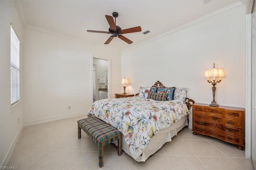 4971 Rustic Oaks Circle Naples, FL 34105 - Photo 30 of 50 a bedroom with a bed and a chandelier