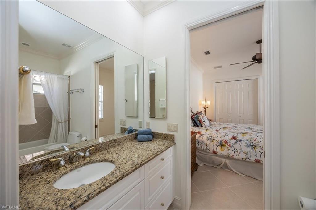 4971 Rustic Oaks Circle Naples, FL 34105 - Photo 32 of 50 a bathroom with a granite countertop sink and a mirror