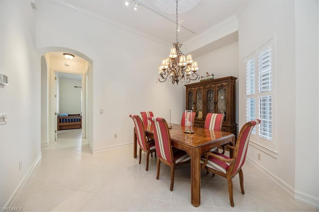 4971 Rustic Oaks Circle Naples, FL 34105 - Photo 7 of 50 a dining room with furniture a chandelier and a rug