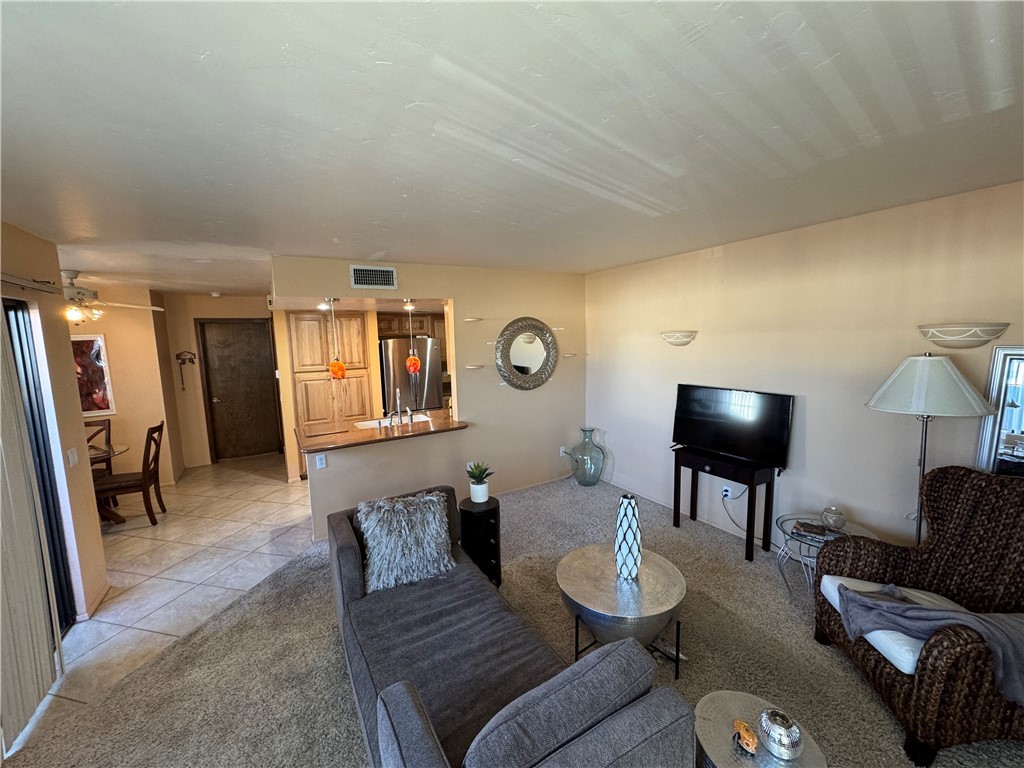 1190 Ramar Road, Unit 15 Bullhead City, AZ 86442 - Photo 2 of 17 Living area featuring light tile patterned floors, ceiling fan, and light colored carpet