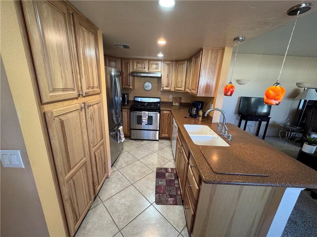 1190 Ramar Road, Unit 15 Bullhead City, AZ 86442 - Photo 4 of 17 Kitchen with a peninsula, light tile patterned floors, appliances with stainless steel finishes, recessed lighting, and dark stone counters