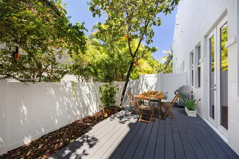 a view of a patio with table and chairs and potted plants with wooden floor