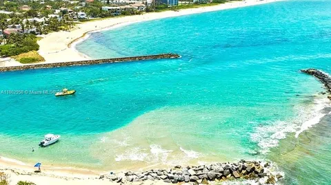 a view of swimming pool with lawn chairs and plants