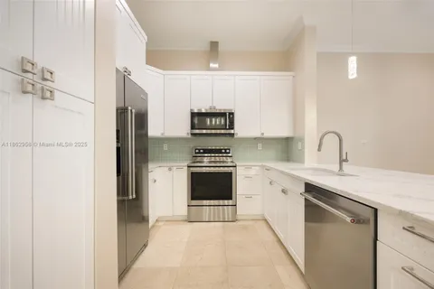 a open kitchen with white cabinets and stainless steel appliances