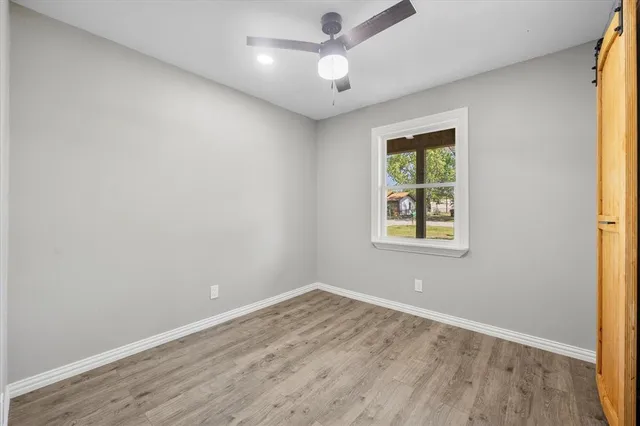 an empty room with a window and a ceiling fan